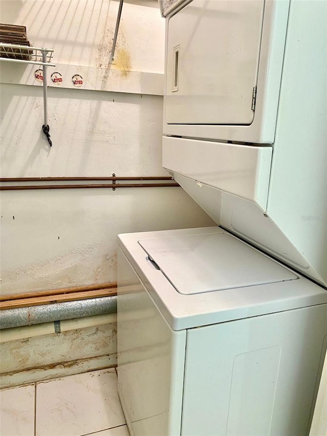 washroom featuring stacked washer / drying machine