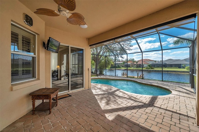 view of swimming pool with glass enclosure, ceiling fan, and a patio