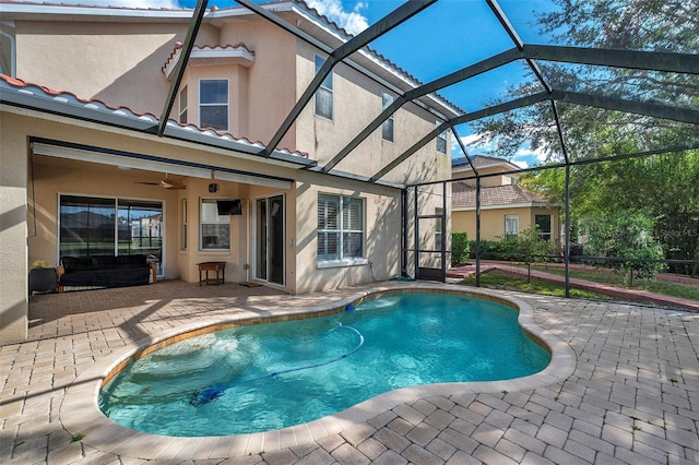 view of pool with ceiling fan, a patio area, and glass enclosure