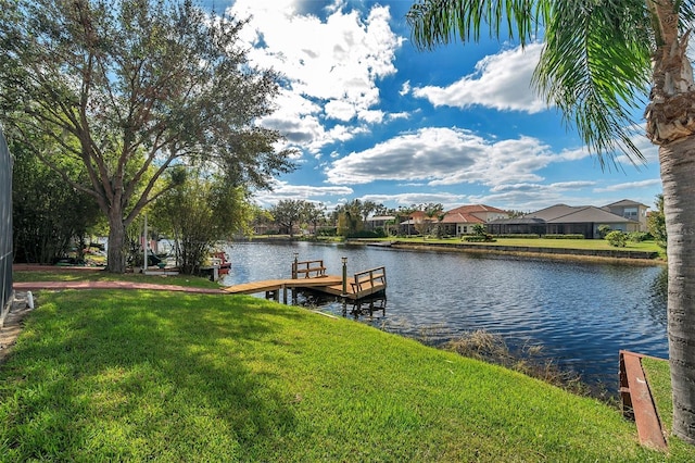 view of dock with a water view and a yard