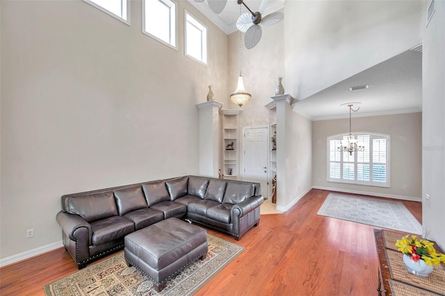 living room with a healthy amount of sunlight, wood-type flooring, and a high ceiling