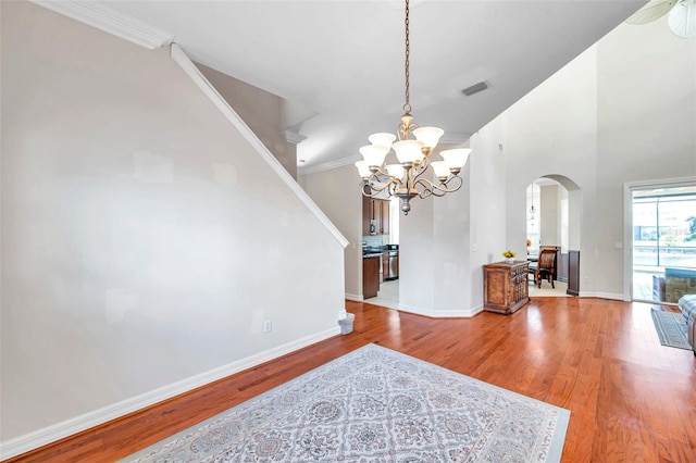 dining area featuring hardwood / wood-style floors, an inviting chandelier, and ornamental molding