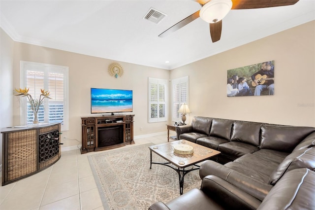 living room with ceiling fan, light tile patterned flooring, and crown molding