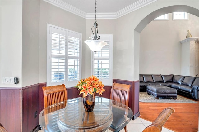 tiled dining area featuring a wealth of natural light and crown molding