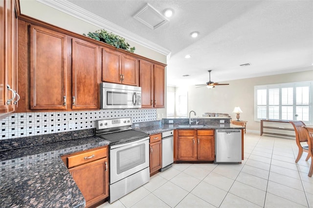 kitchen with decorative backsplash, sink, stainless steel appliances, and ornamental molding