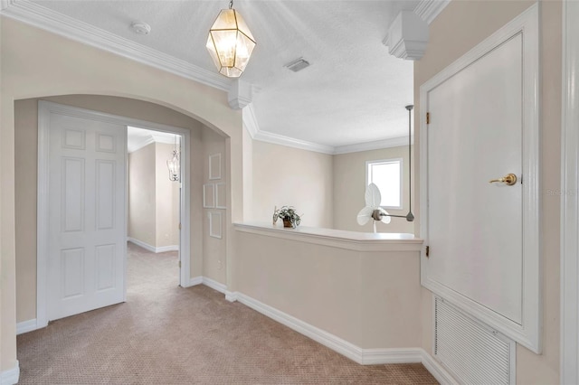 corridor featuring a textured ceiling, light colored carpet, and crown molding