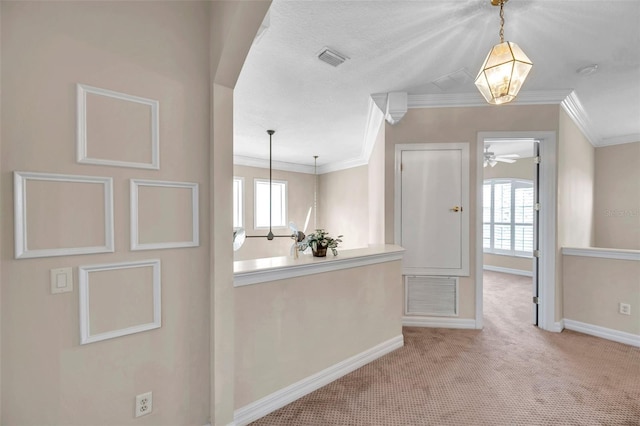 kitchen with crown molding, pendant lighting, ceiling fan, and light colored carpet