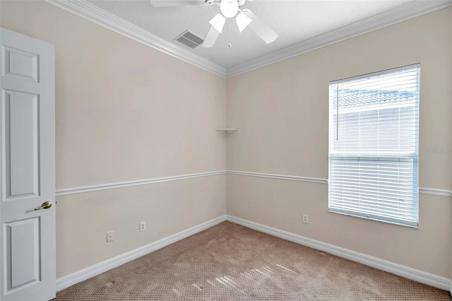 empty room featuring light carpet, a textured ceiling, ceiling fan, and crown molding