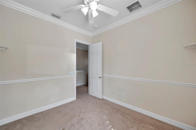 spare room with light carpet, ceiling fan, a textured ceiling, and ornamental molding