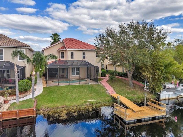 rear view of property featuring a lanai, a patio area, a lawn, and a water view