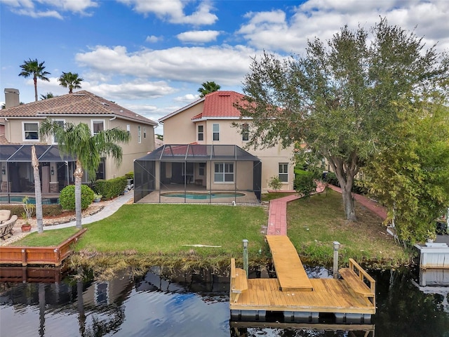 back of property featuring a lawn, glass enclosure, a patio area, and a water view