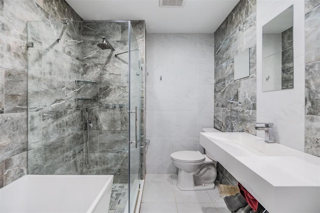 bathroom featuring sink, tile patterned floors, an enclosed shower, toilet, and tile walls