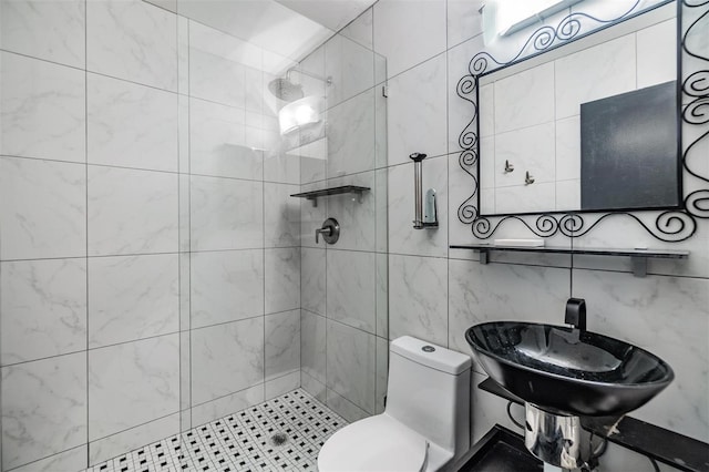 bathroom featuring toilet, sink, and a tile shower