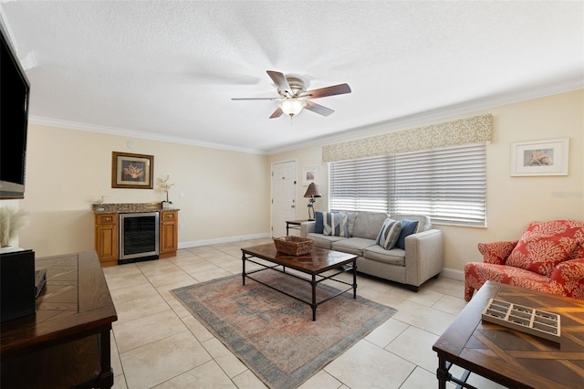 tiled living room with a textured ceiling, ceiling fan, crown molding, and wine cooler