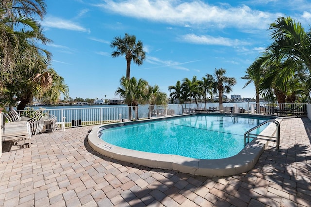 view of swimming pool with a patio area and a water view