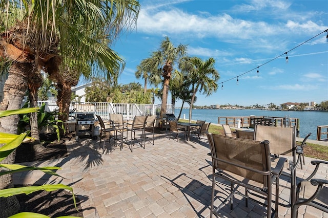 view of patio featuring a water view and a grill