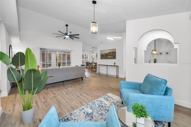 living room with wood-type flooring, a textured ceiling, and ceiling fan