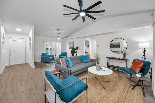 living room with light hardwood / wood-style floors, vaulted ceiling, and ceiling fan