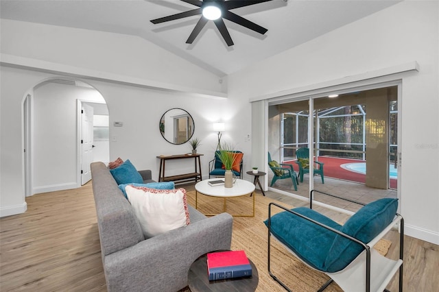 living room with ceiling fan, light hardwood / wood-style flooring, and vaulted ceiling