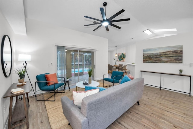 living room featuring light hardwood / wood-style flooring, ceiling fan, and lofted ceiling