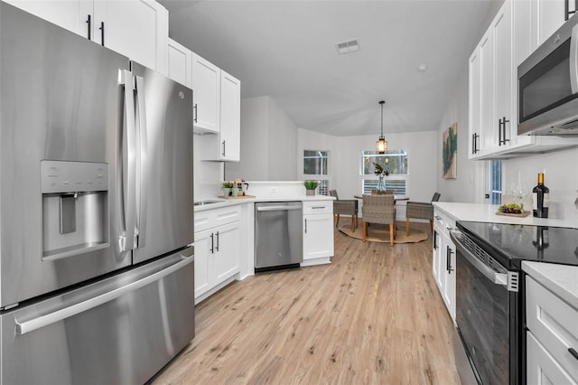 kitchen with white cabinetry, stainless steel appliances, and light wood-type flooring