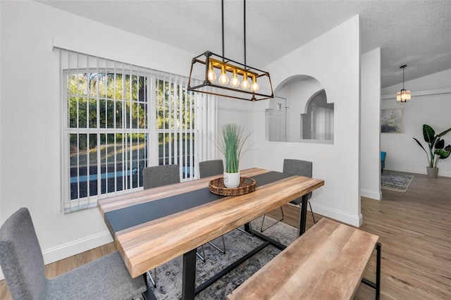 dining area with wood-type flooring and a textured ceiling