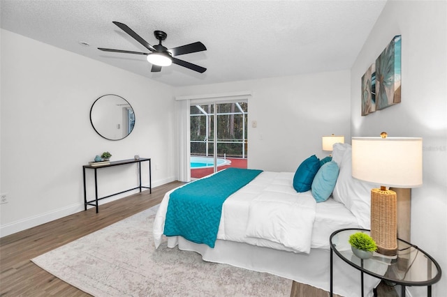 bedroom with access to outside, ceiling fan, dark wood-type flooring, and a textured ceiling