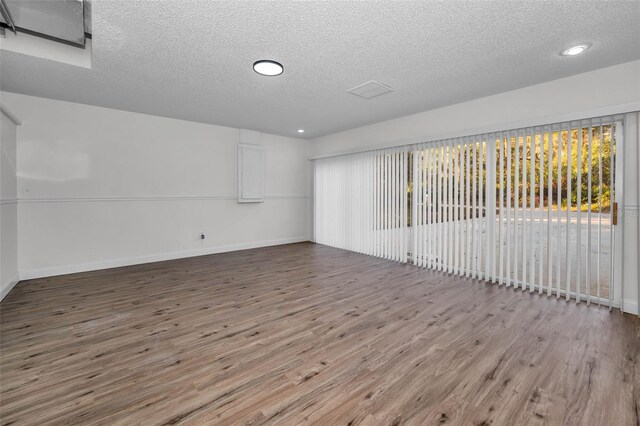 empty room featuring hardwood / wood-style flooring and a textured ceiling