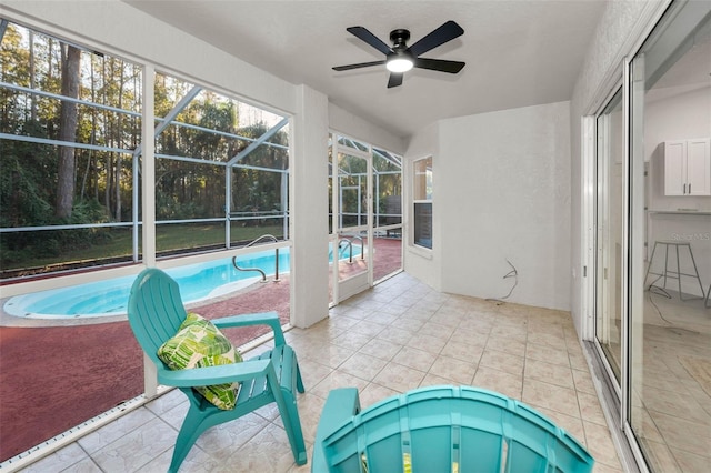 view of pool with glass enclosure, ceiling fan, and a patio area