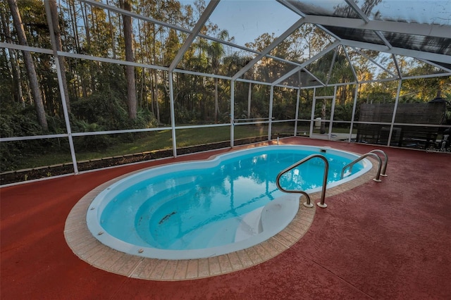 view of pool featuring glass enclosure and a patio