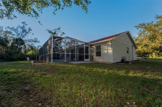 back of property featuring a lawn and glass enclosure