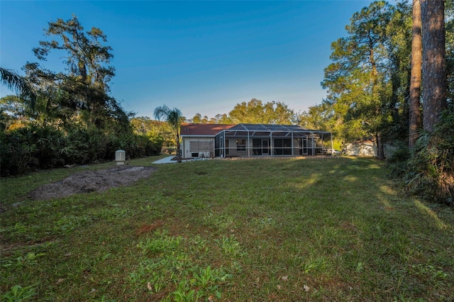 back of property with a yard and a lanai