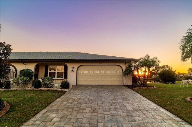 ranch-style house featuring a yard and a garage