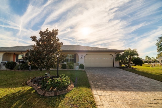 ranch-style house featuring decorative driveway, a front yard, an attached garage, and stucco siding