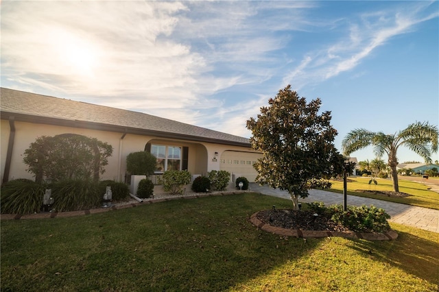 ranch-style home with a garage and a front lawn