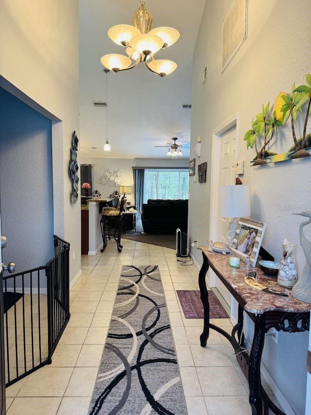 corridor with light tile patterned floors and a chandelier