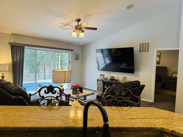 living room featuring dark carpet, a textured ceiling, vaulted ceiling, and ceiling fan