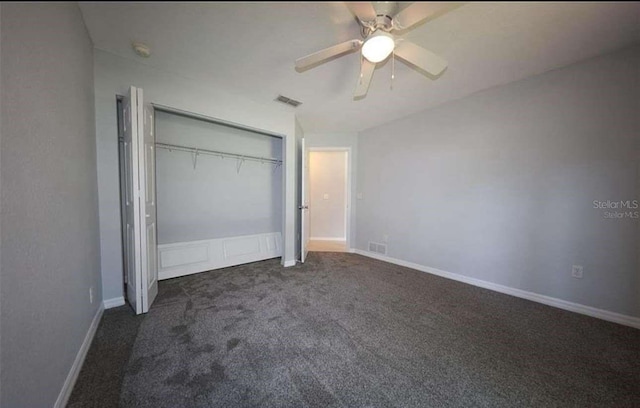 unfurnished bedroom featuring ceiling fan, dark carpet, and a closet