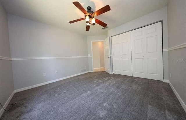 unfurnished bedroom with a closet, dark carpet, and ceiling fan