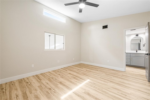 unfurnished bedroom featuring connected bathroom, multiple windows, ceiling fan, and light hardwood / wood-style flooring