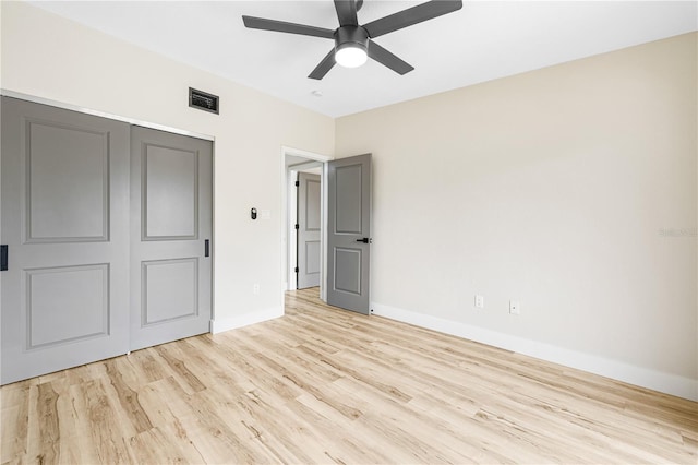 unfurnished bedroom featuring light wood-type flooring, a closet, and ceiling fan