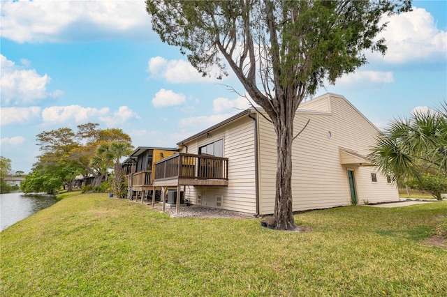 rear view of property featuring central AC unit, a yard, and a wooden deck