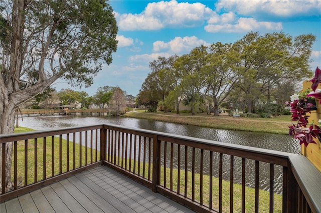 wooden deck with a yard and a water view