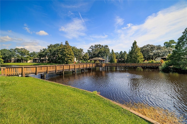 view of dock with a yard and a water view