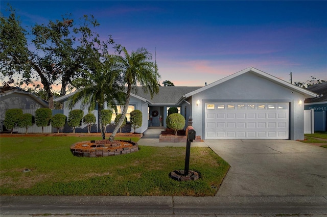 ranch-style home featuring a yard and a garage