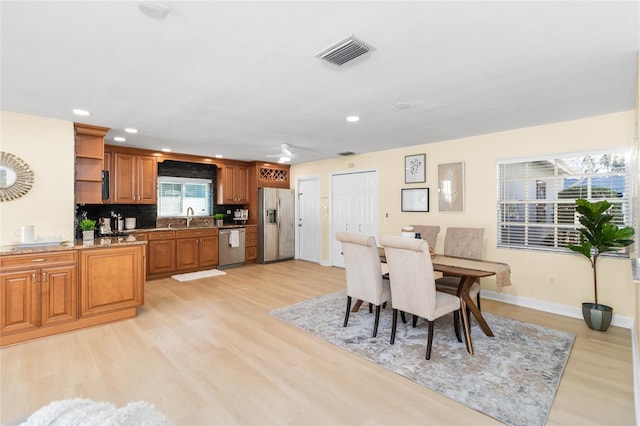 dining room featuring sink and light wood-type flooring