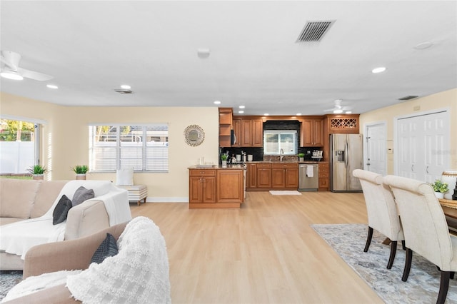 living room featuring light hardwood / wood-style floors, ceiling fan, and sink