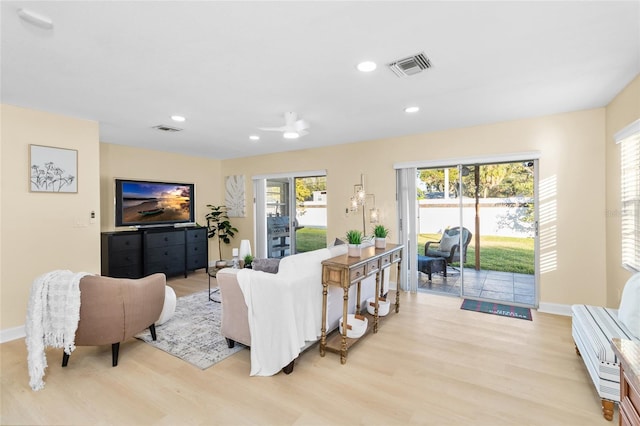 living room featuring light hardwood / wood-style flooring and ceiling fan