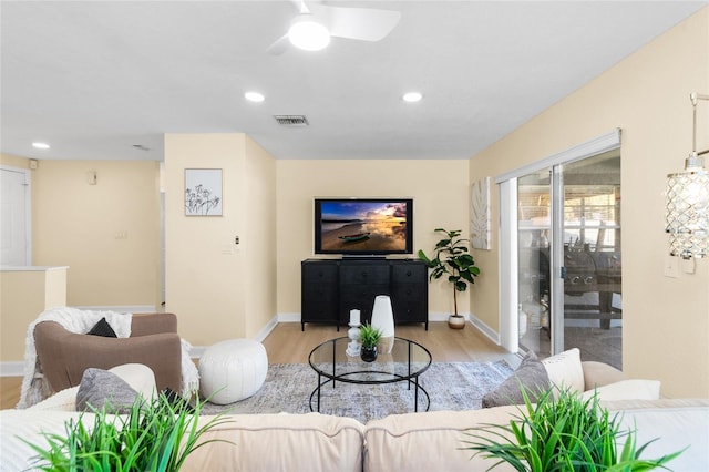 living room with ceiling fan and light hardwood / wood-style flooring