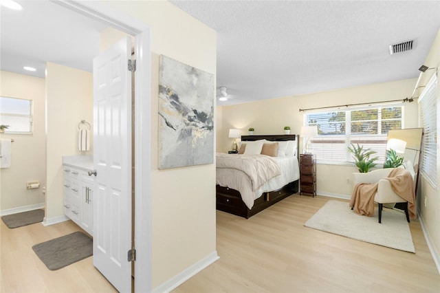 bedroom with a textured ceiling and light hardwood / wood-style floors